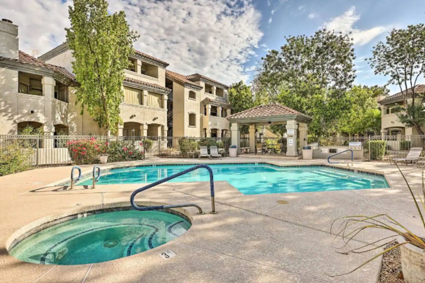 A swimming pool with a gazebo, surrounded by multi-story buildings with balconies.