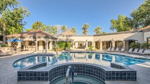 A pool area with a hot tub, lounge chairs, and a covered seating area. - Modern North Scottsdale Condo – Resort Style Amenities, 1st Floor Corner Unit (Scottsdale)