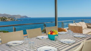 Un área de comedor al aire libre con una mesa para dos, con vista al mar.