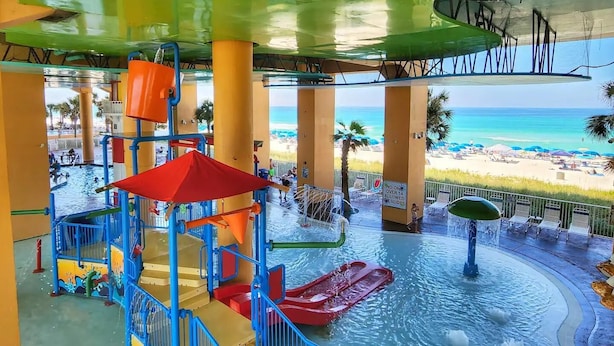 A water park with slides and pools, overlooking a beach. - PARADISE FOUND! 2ND FL BEACHFRONT CONDO W/KITCHEN, POOLS, WATERPARK & OTHER FUN! (Panama City Beach)