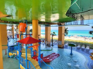 Un parc aquatique avec des toboggans et des piscines, offrant une vue sur la plage.