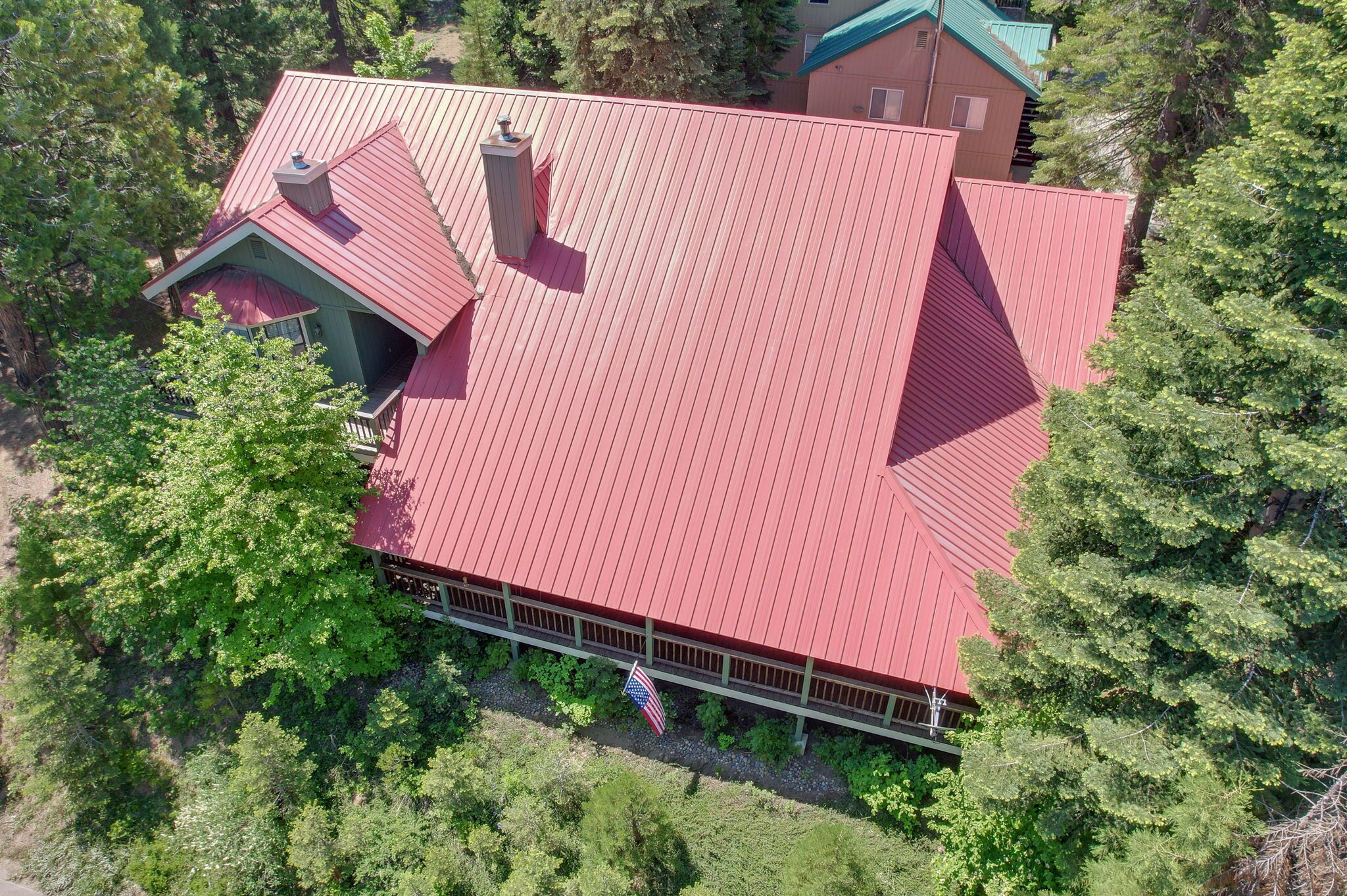 A large, red-roofed building surrounded by trees, with an American flag visible.