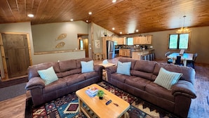A spacious living area with two brown sofas, a wooden coffee table, and a colorful rug. - Bear Paw Lodge • Luxury Cabin • Game Room • Fire Pit (Wisconsin Dells)