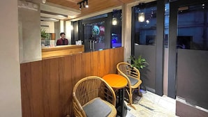A reception area with a wooden counter, two wicker chairs, and a reception desk. - Anex Hotel-Manila (Manila)