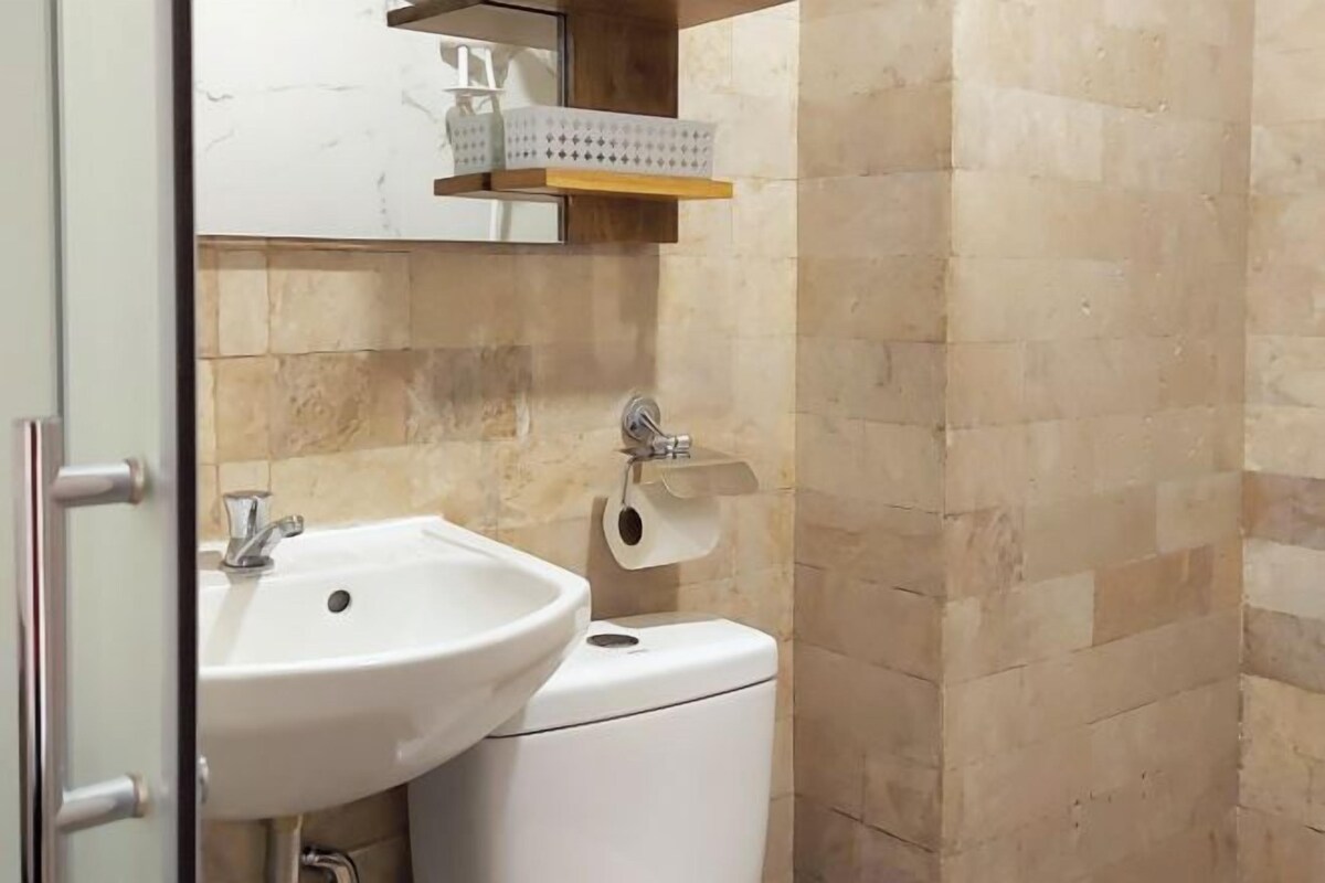 A bathroom with a white sink, toilet, and a towel rack.