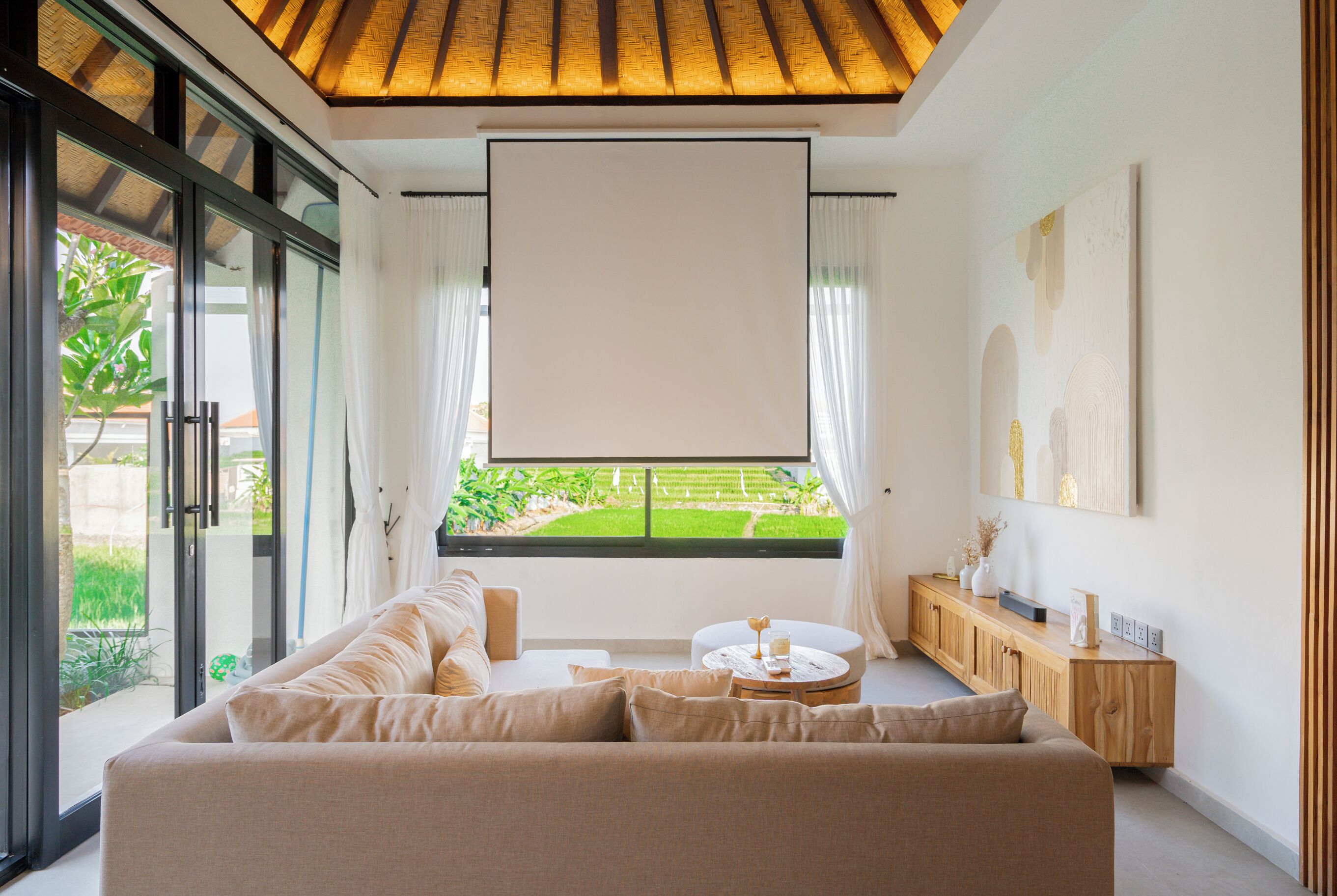Een moderne woonkamer met een groot raam, een bank, een salontafel en een houten kast.