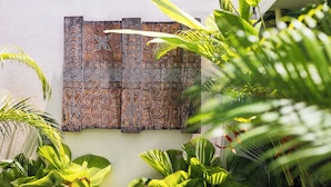 A wall with a decorative panel featuring intricate patterns. - Beautiful 1 bedroom villa in perfect location (Bali)