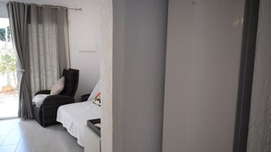 A bedroom with a bed, a chair, and a wardrobe.