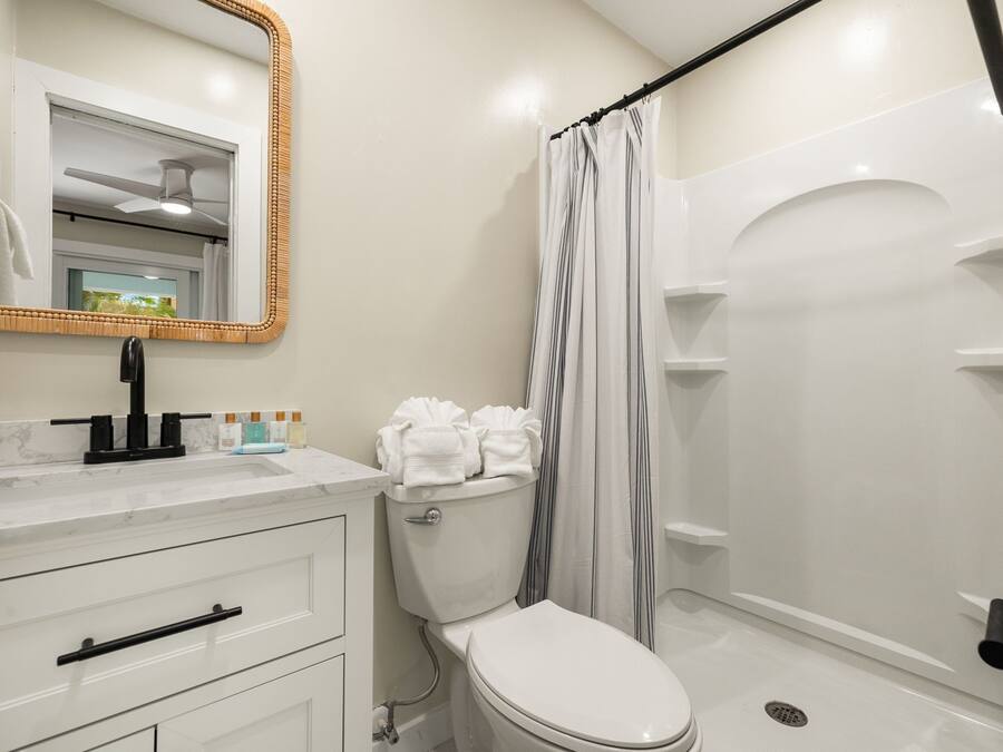 A bathroom with a toilet, sink, and shower.