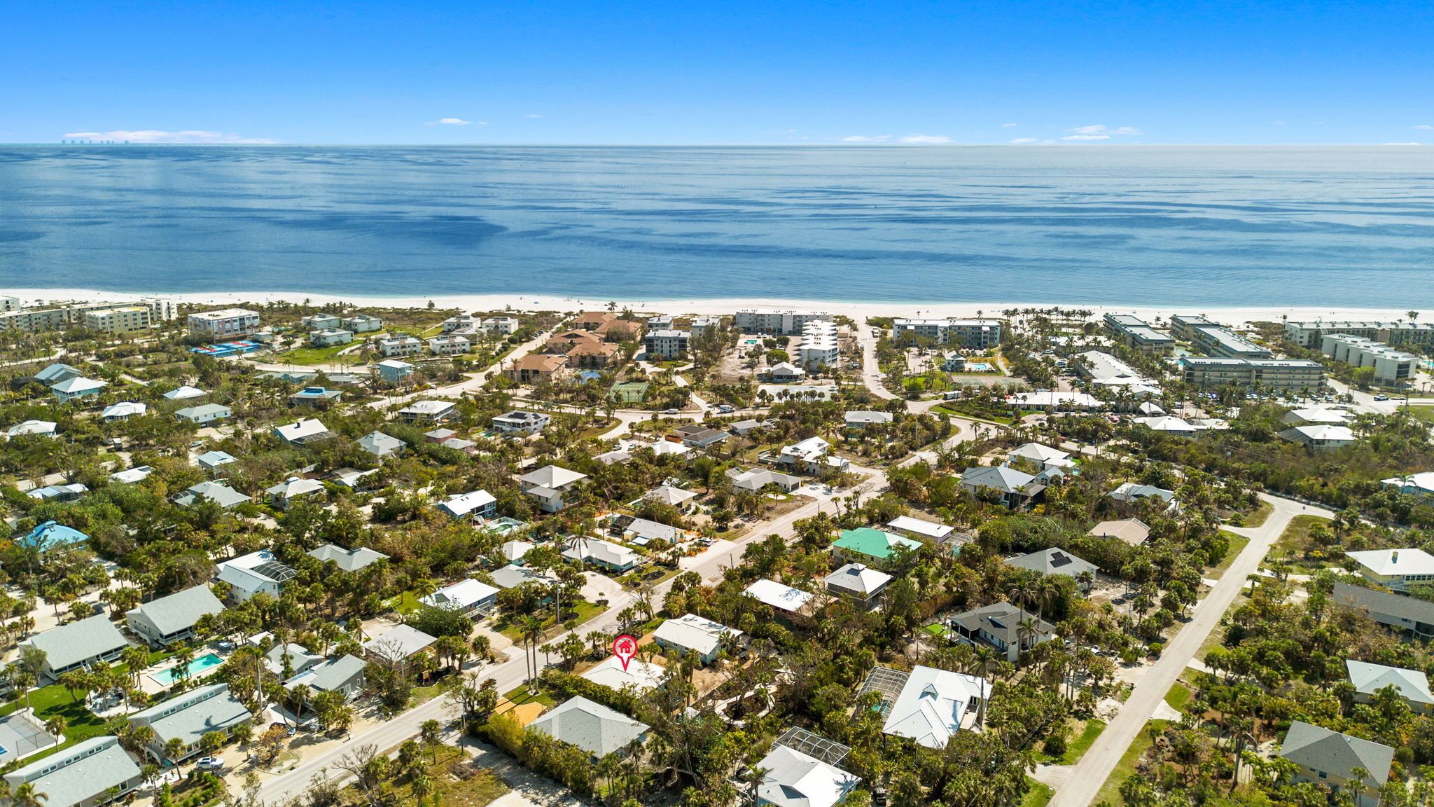 A coastal residential area with houses, roads, and a beach.