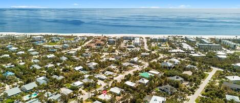 A coastal residential area with houses, roads, and a beach.