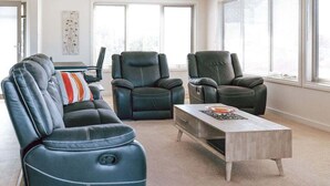 A living room with a sofa, two recliner chairs, and a coffee table. - Mara House - Space for Everyone (Break O'Day)