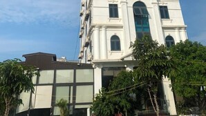 A tall, white building with the sign "ROYAL HOTEL" on the front. - Royal Hotel Cua Lo Beach (Cua Lo)