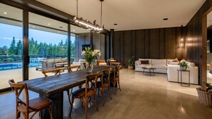 A modern interior with a dining area, a sofa, and a fireplace. - Riverbank  - Hosted by NZSIR Luxury Rental Homes (Wānaka)