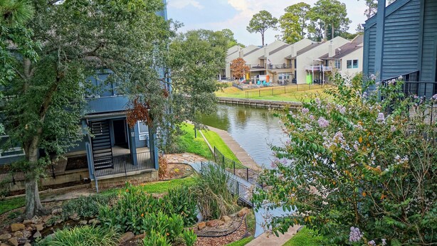 A residential area with a waterway, a covered outdoor seating area, and a variety of trees and shrubs. - Lake Conroe w/Theatre, Views, & Boat Launch Access & Walden's endless amenities  (Montgomery)