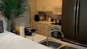 A modern kitchen with white cabinets, stainless steel appliances, and pendant lighting. - Lake Conroe w/Theatre, Views, & Boat Launch Access & Walden's endless amenities  (Montgomery)