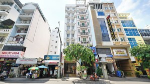 A hotel with a sign reading "HOTEL SPRING" and a balcony with a view of the street. - Sunrise Airport Hotel (Ho Chi Minh City)