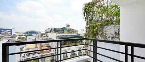 A balcony with a view of surrounding buildings and a clear sky.