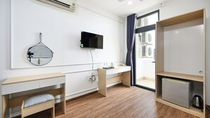 A modern hotel room with a wooden desk, a flat-screen TV, a mini-fridge, and a built-in heater. - Sunrise Airport Hotel (Ho Chi Minh City)