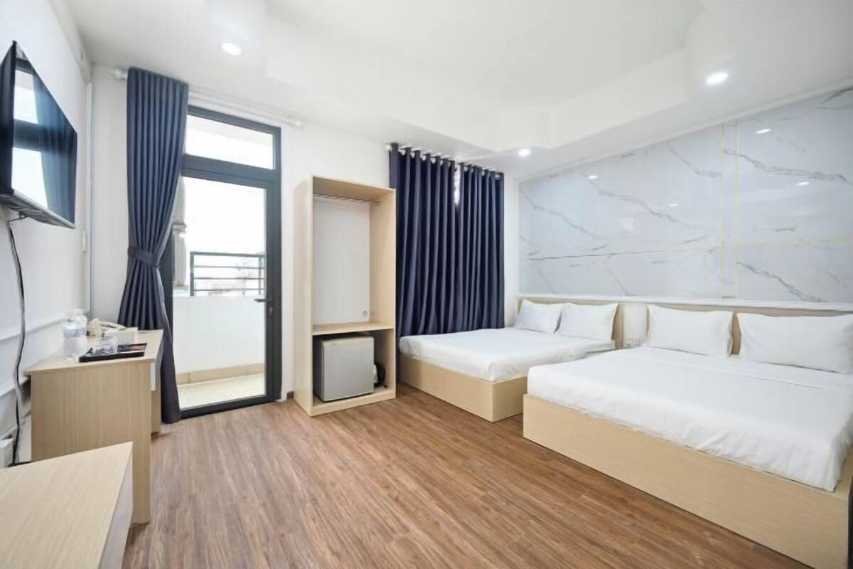 Une chambre d’hôtel moderne avec un plancher en bois, un grand lit, un bureau et une télévision.