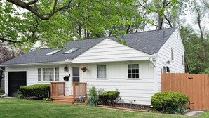 A single-story house with a front porch, a garage, and a wooden fence. - Go Buckeyes!Stylish 3-Level Haven Near OSU,PS5,Skylight, Fully fenced Backyard (Columbus)