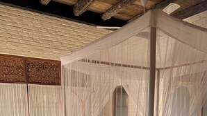 A room with a four-poster canopy bed, wooden flooring, and a brick wall. - Guava House by The Serendipity Collection (Hemmathagama)