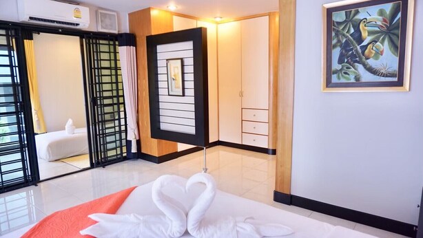 Ein Hotelzimmer mit einem Bett, einem großen Spiegel, einem Gemälde und einem Kleiderschrank.