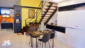 Eine moderne Küche mit Essbereich, Treppe und Kücheninsel.