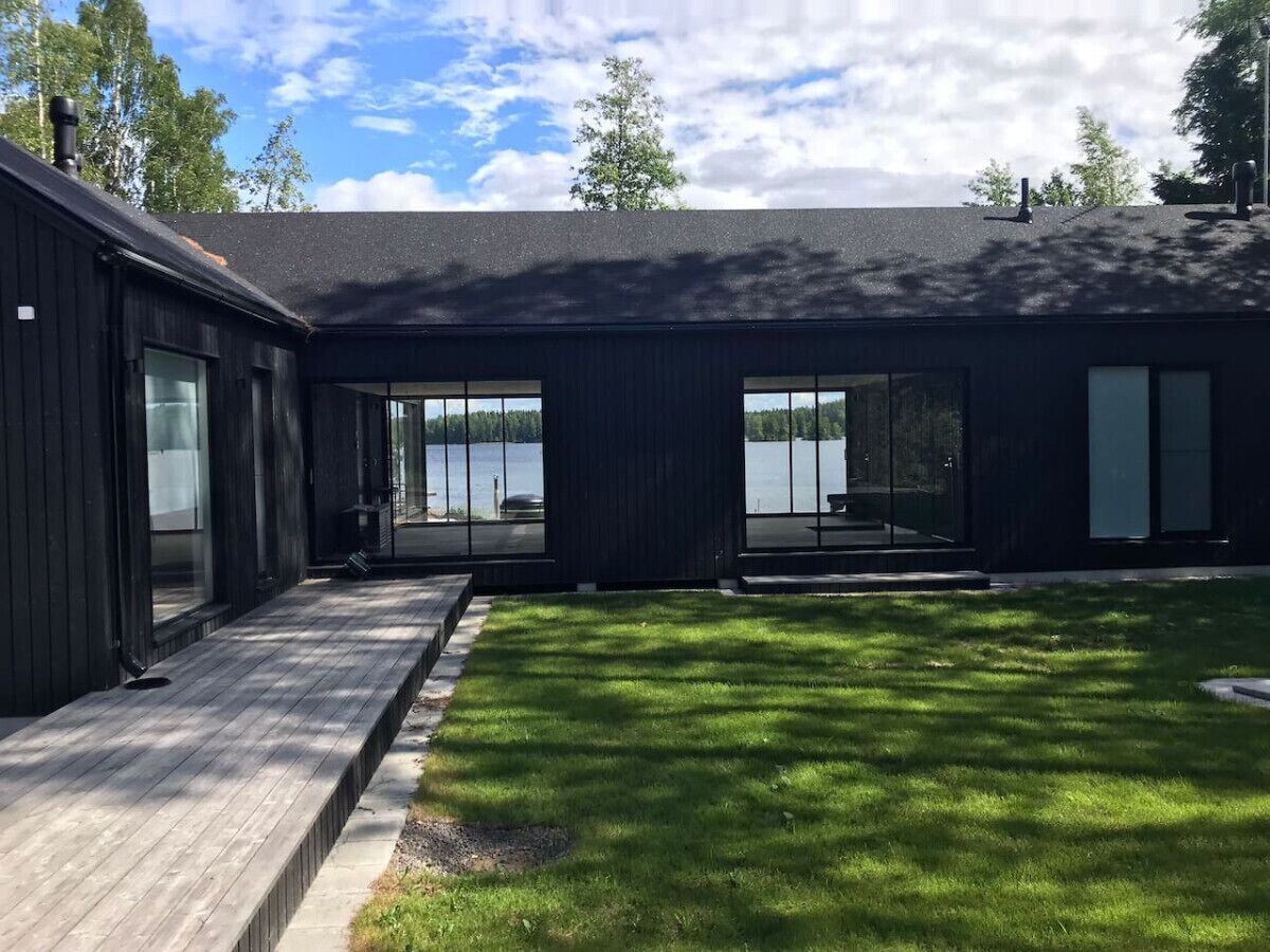 A modern building with large windows overlooking a body of water.