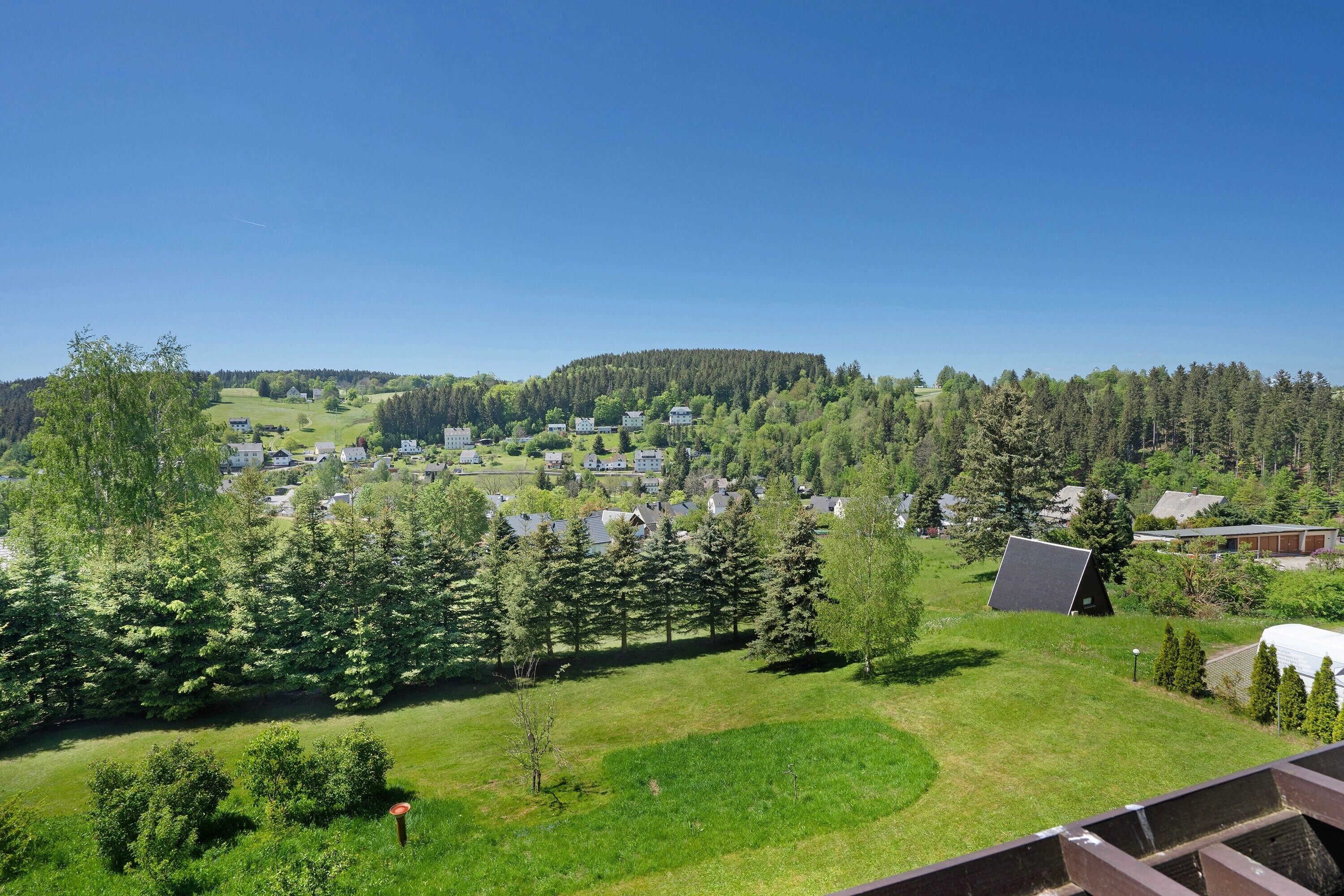 Ein Wohngebiet mit Häusern, Bäumen und blauem Himmel.