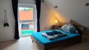 Ein Schlafzimmer mit einem Bett, einer Lampe und einem Fenster.