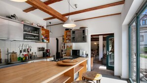 Una cocina moderna con encimeras de madera, horno empotrado y un amplio ventanal.