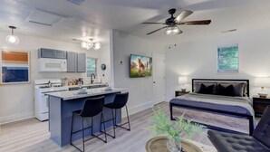Apartament modern amb cuina, zona de menjador i dormitori amb llit i nits.
