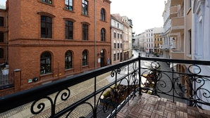 Un bâtiment en briques doté de fenêtres en arc de cercle et d’un balcon orné de balustrades en fer forgé.