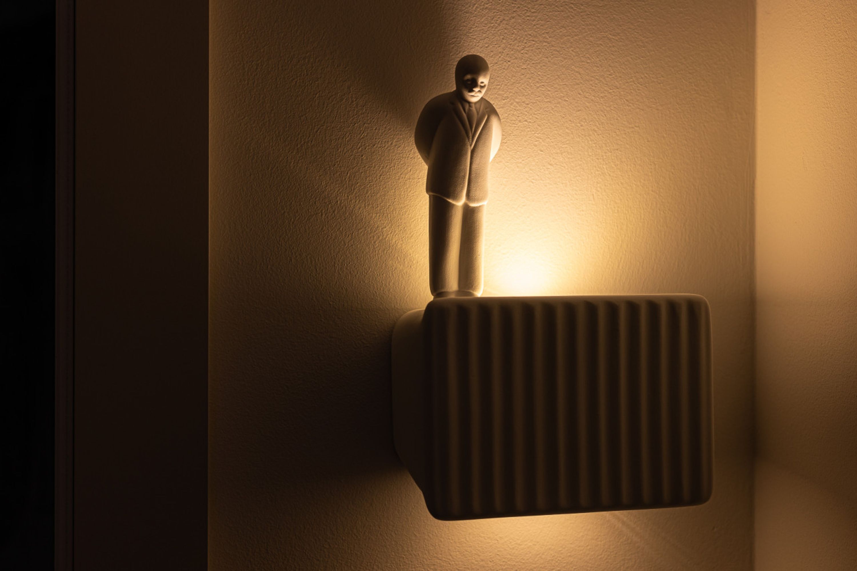A wall-mounted radiator with a figure standing on it.