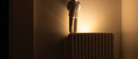 A wall-mounted radiator with a figure standing on it.