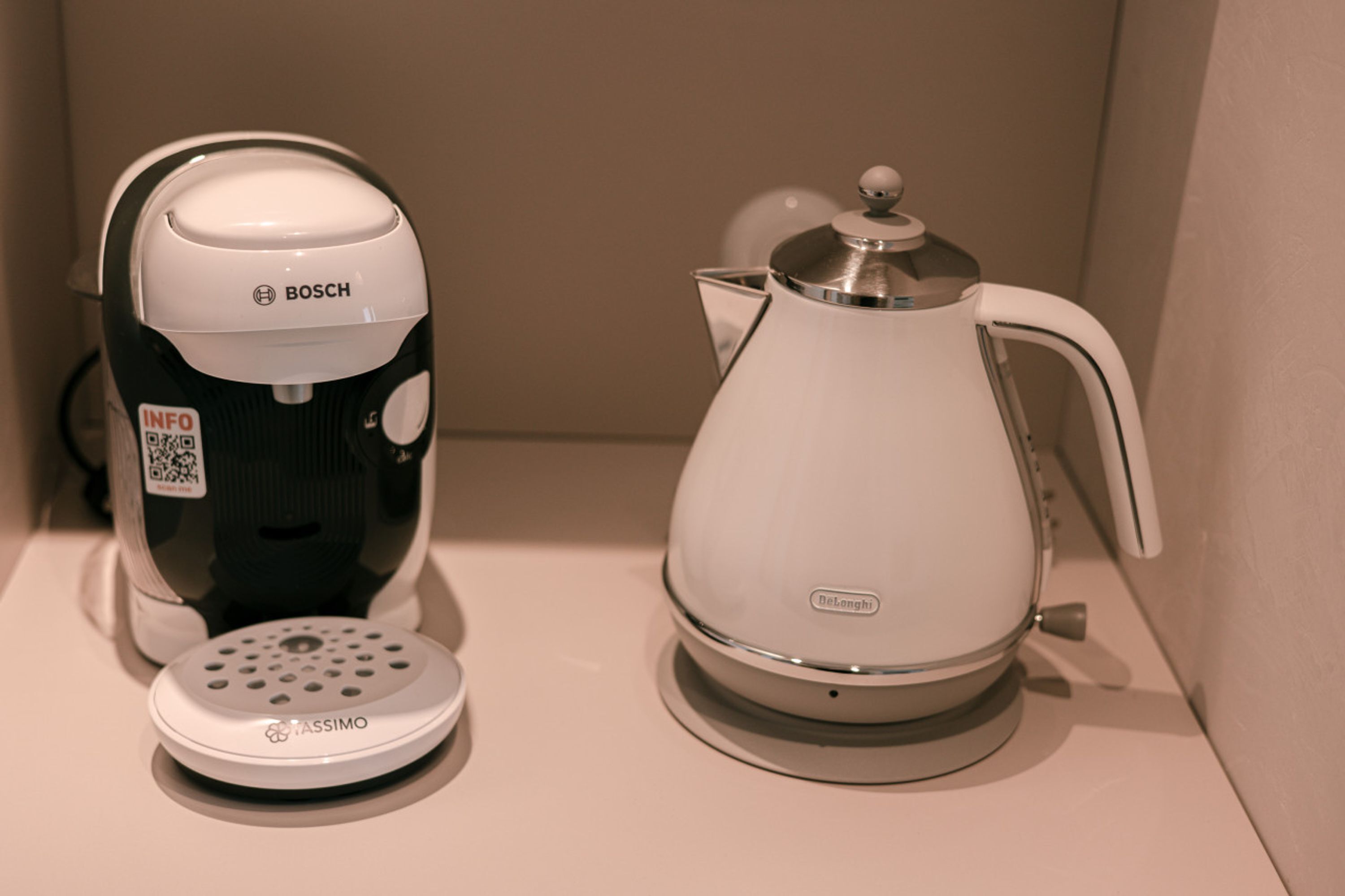 Eine Kaffeemaschine und ein Teekessel auf einer Arbeitsplatte.