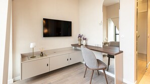 A modern living room with a flat-screen TV mounted on the wall, a dining table with chairs, and a large mirror reflecting the room. - Rio 2 Panorama Bydgoszczy Luksus w Centrum (Bydgoszcz)