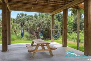 A wooden picnic table under a wooden pergola with hammocks hanging. - Beautiful Mermaid Cove - Brand New with Hot Tub (Galveston)