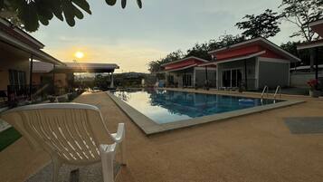 Una piscina al aire libre, sombrillas, tumbonas