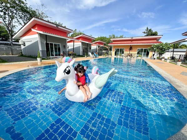 Una piscina al aire libre, sombrillas, tumbonas
