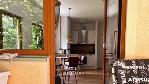 Una camera da letto con una grande finestra, vista sulla cucina e zona pranzo.