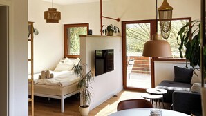 Un soggiorno moderno e open space con un letto, divano, tavolo da pranzo e un'ampia finestra.
