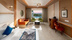 Una habitación de hotel moderna con cama, sofá, escritorio y balcón con vistas.