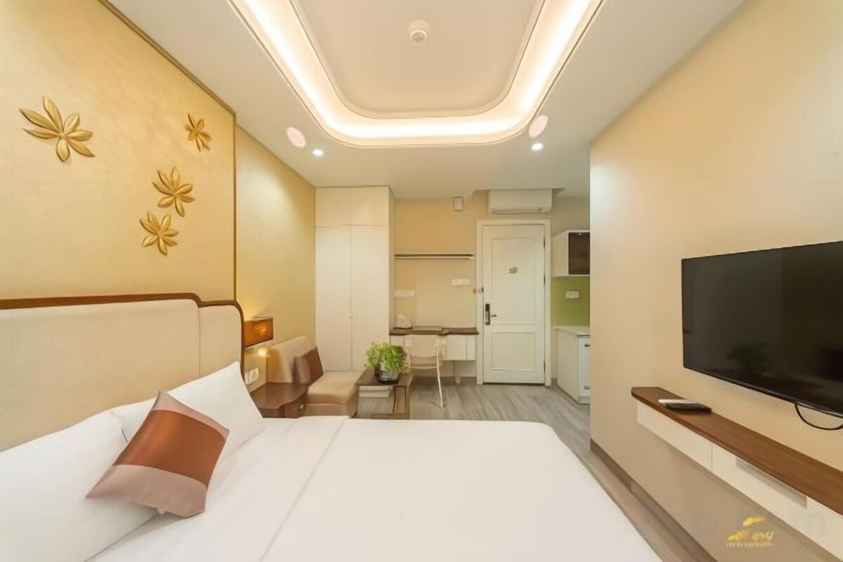 Une chambre d’hôtel équipée d’un lit, d’une télévision, d’un bureau et d’une kitchenette.
