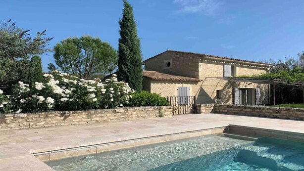 A pool area with a stone wall and a building in the background. - TRANQUIL RETREAT: DISCOVER PICTURESQUE COUNTRYSIDE FARMHOUSE WITH POOL (Ménerbes)