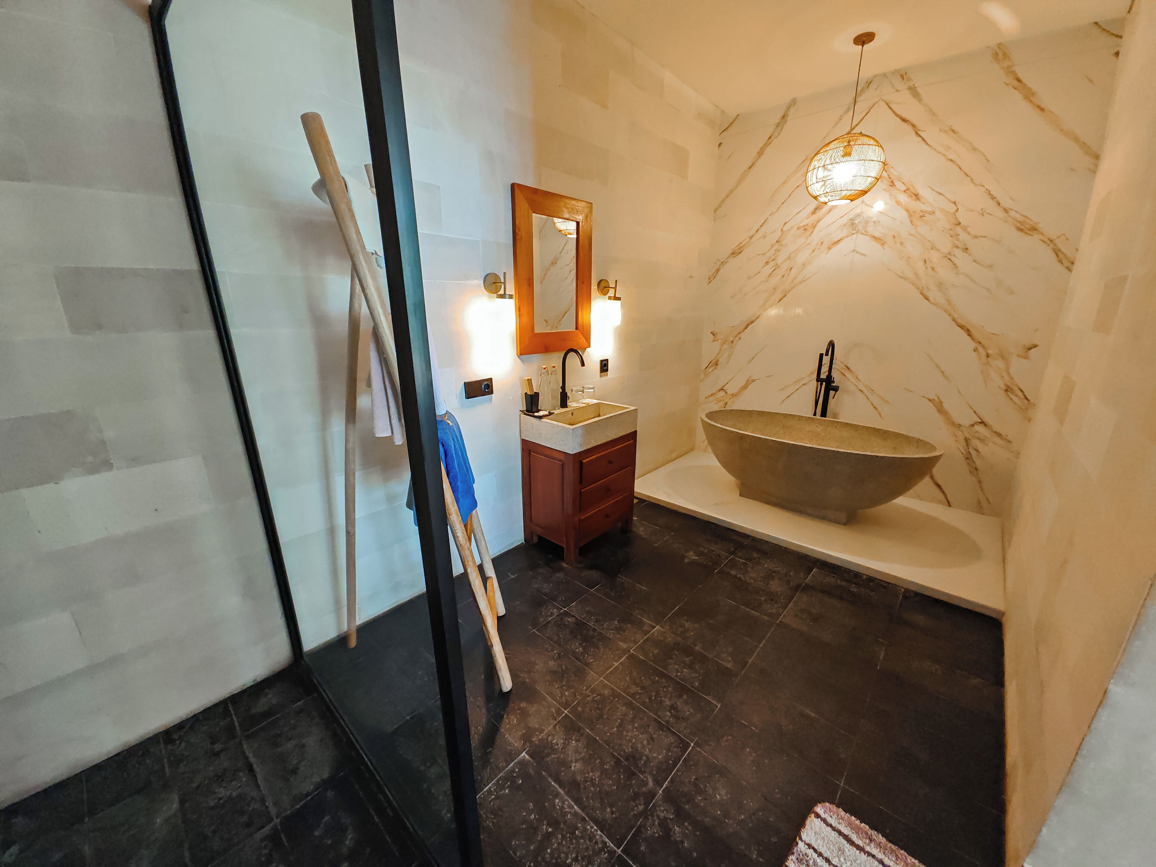 Une salle de bain moderne avec une grande baignoire sur pieds, un meuble-lavabo en bois et un miroir au-dessus du lavabo.