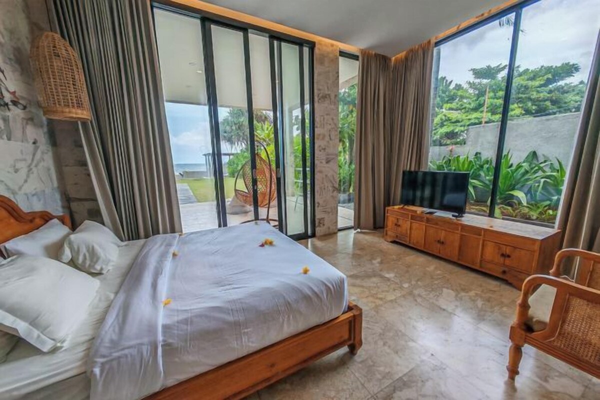 Une chambre avec un lit, une télévision, une armoire en bois et une vue sur la verdure.