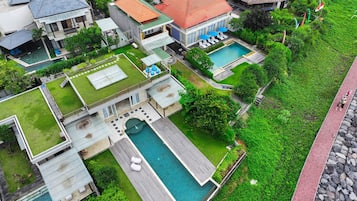 Vista aérea de una zona residencial con varias casas, una piscina y un jardín bien cuidado.