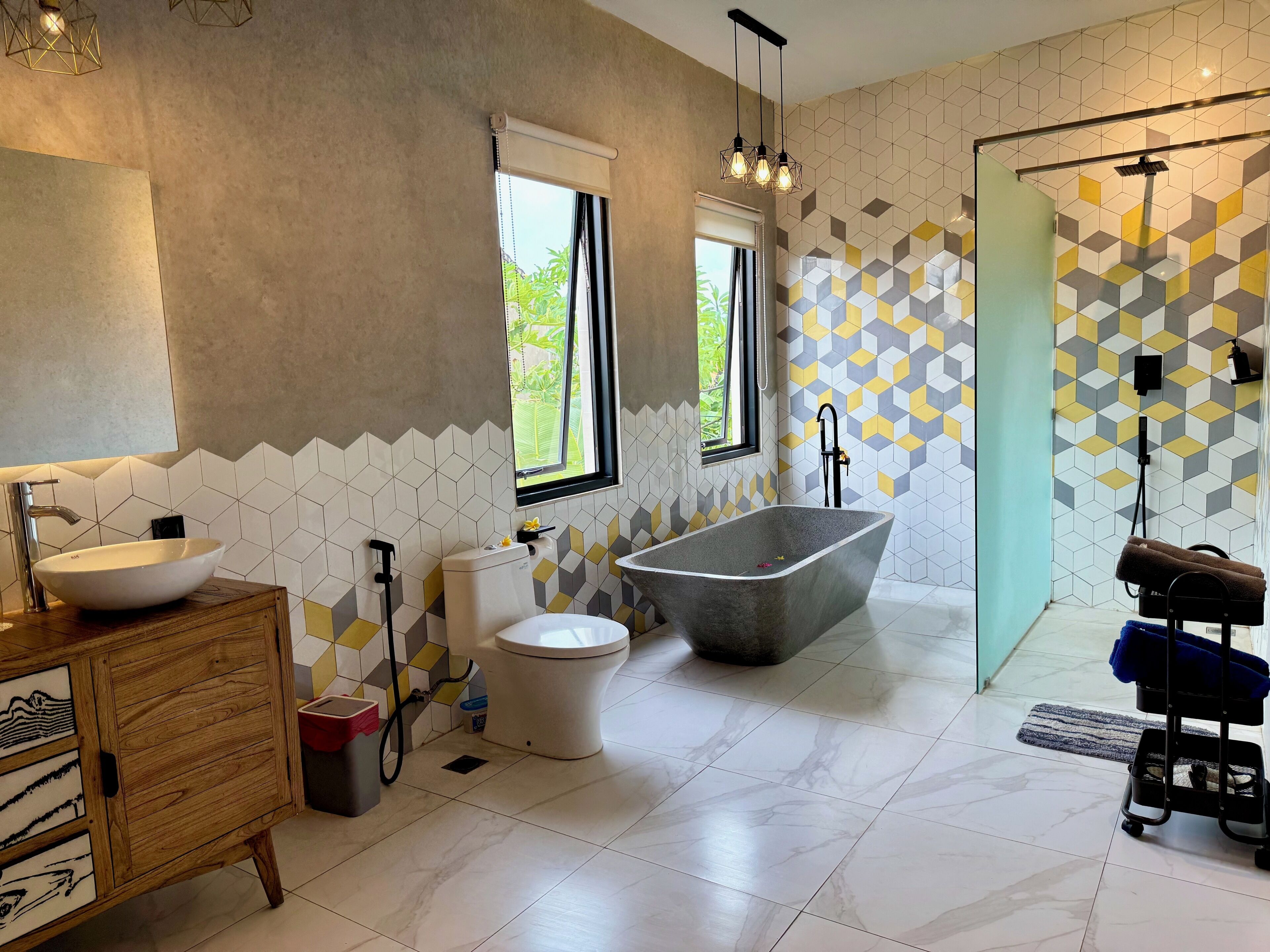A modern bathroom with a freestanding bathtub, a vessel sink, and a toilet.
